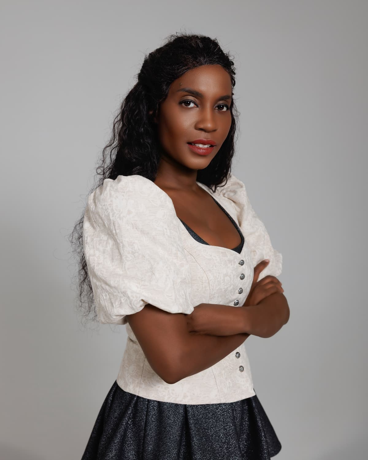 Sadia De Kiden in weißer Bluse mit verschränkten Armen